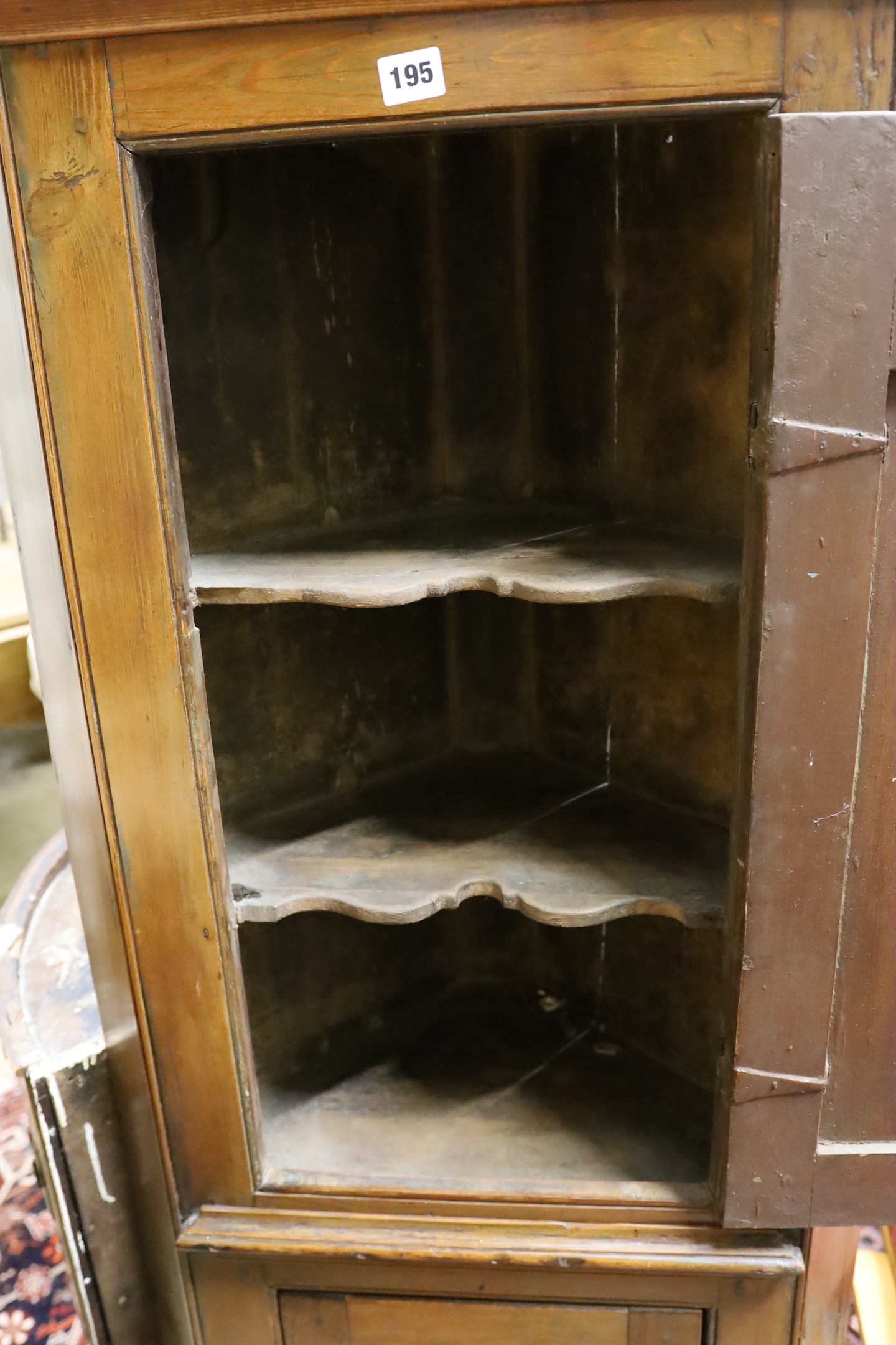 A small early 19th century pine two door standing corner cabinet, (lacking back leg) width 58cm, depth 30cm, height 150cm